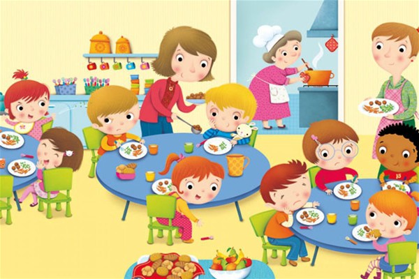 Bambini seduti a tavola mentre consumano il pasto, affiancati dal personale addetto alla mensa.