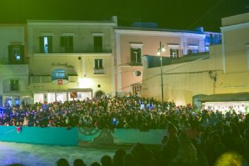 La pista di ghiaccio animata da numerosi visitatori durante lo spettacolo di intrattenimento natalizio.