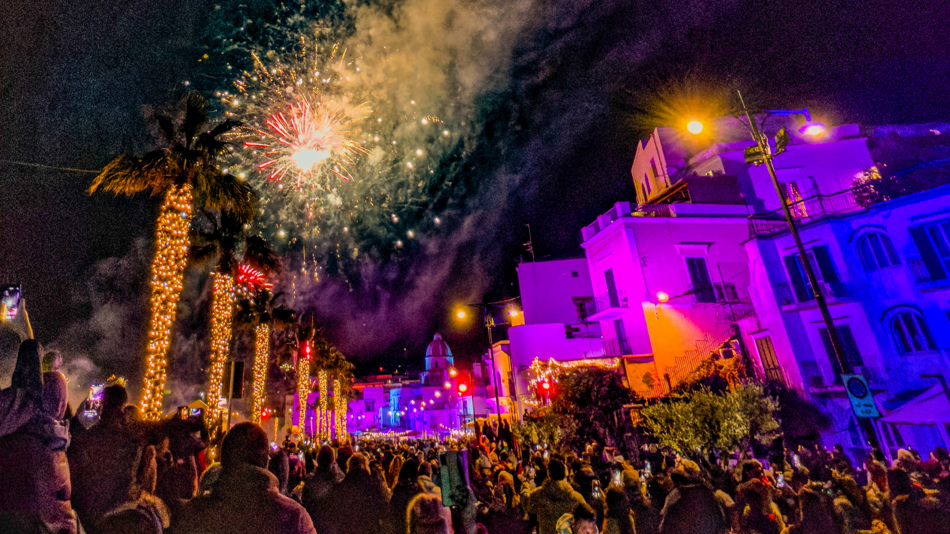 Scena natalizia con lo sfondo del paesaggio di Forio illuminato da fuochi d’artificio.