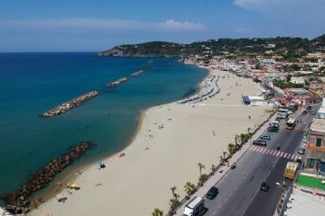 Vista dall’alto, la Spiaggia della Chiaia si distende come una lunga fascia di sabbia dorata affacciata su un mare limpido e cristallino, incorniciata da un paesaggio costiero armonioso.